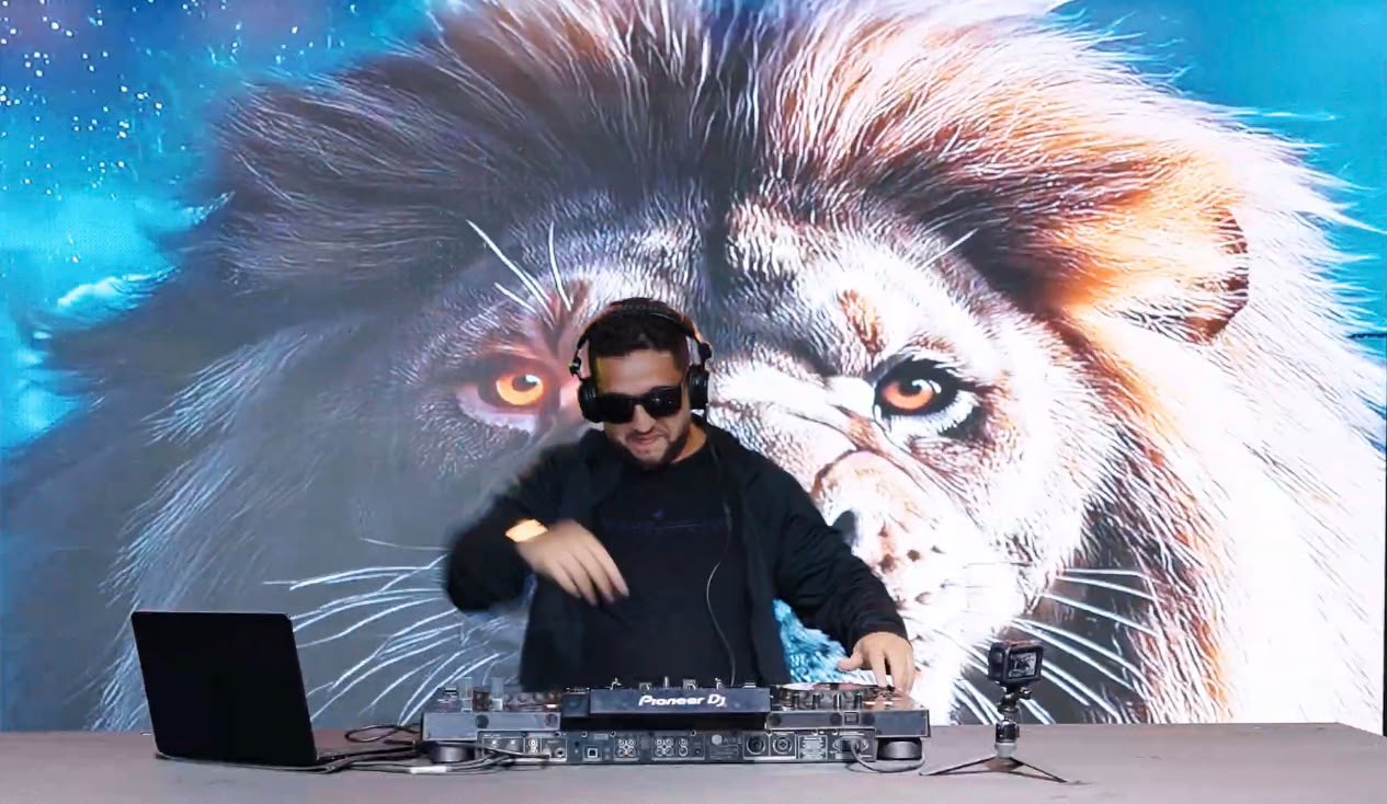 DJ Atnilson no Pioneer DJ com fundo de leão